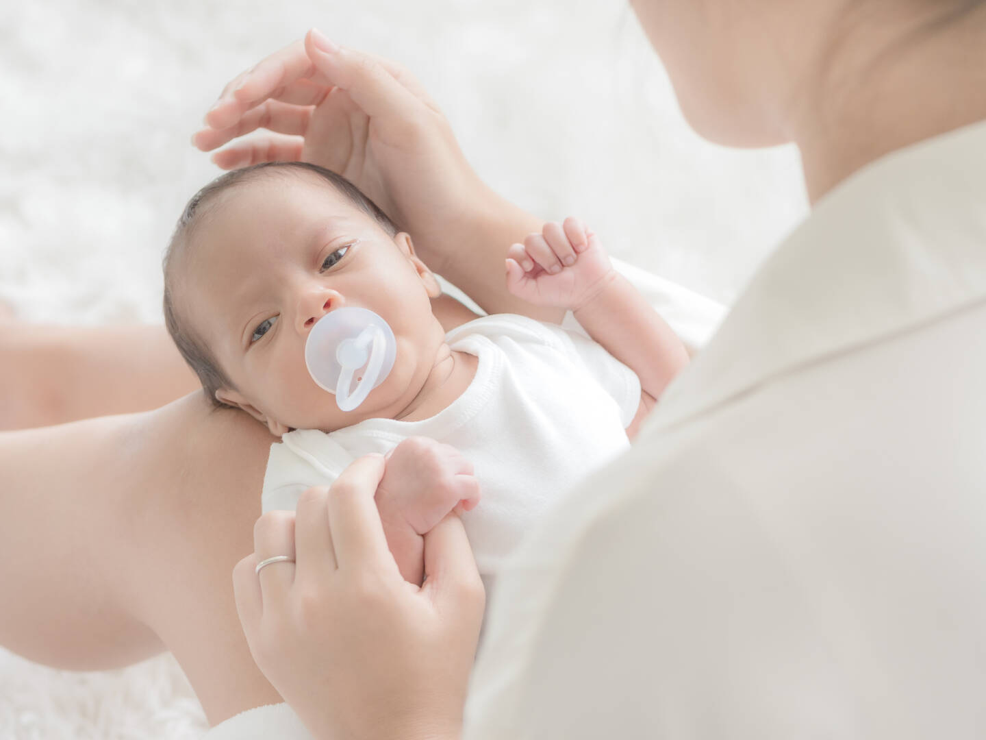 A beautiful Asian woman puts her newborn baby on her body