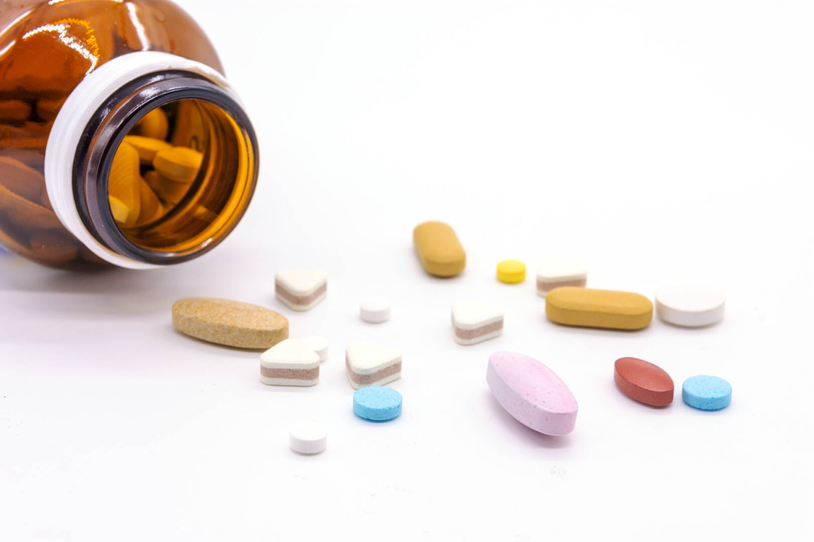 Difference tablets pills heap mix isolated on white background.