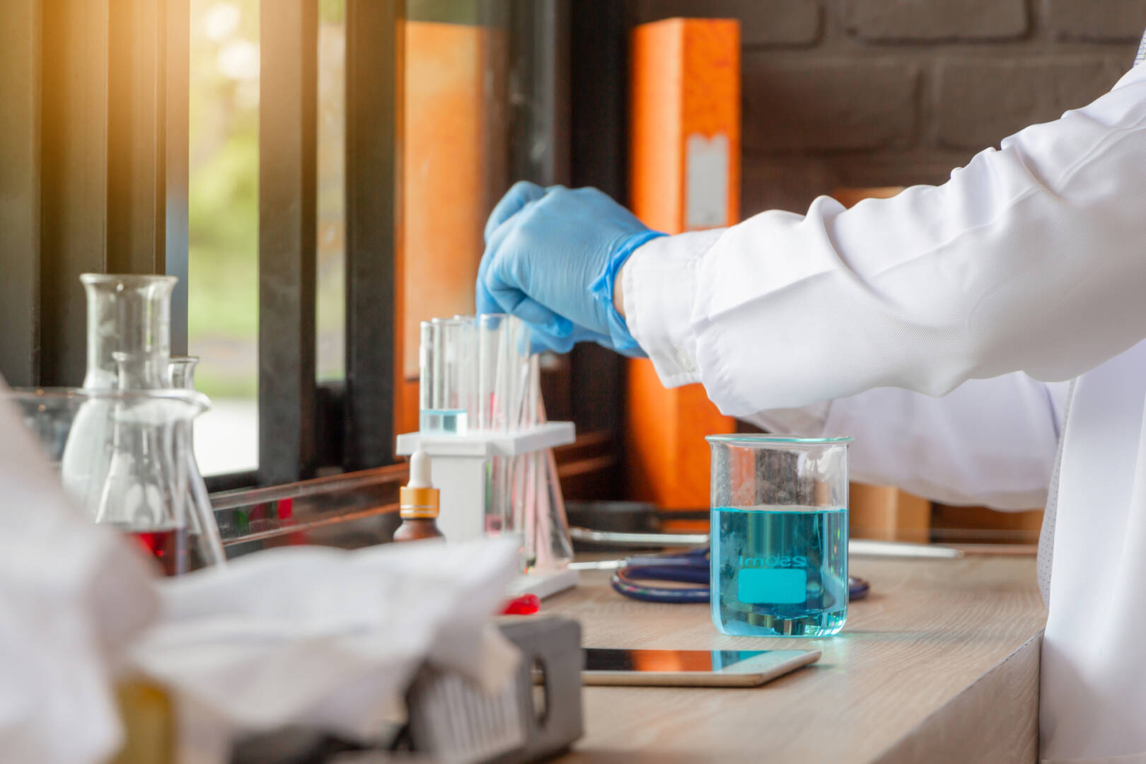 Doctor analyzing medical test tubes examining beaker with fluid,