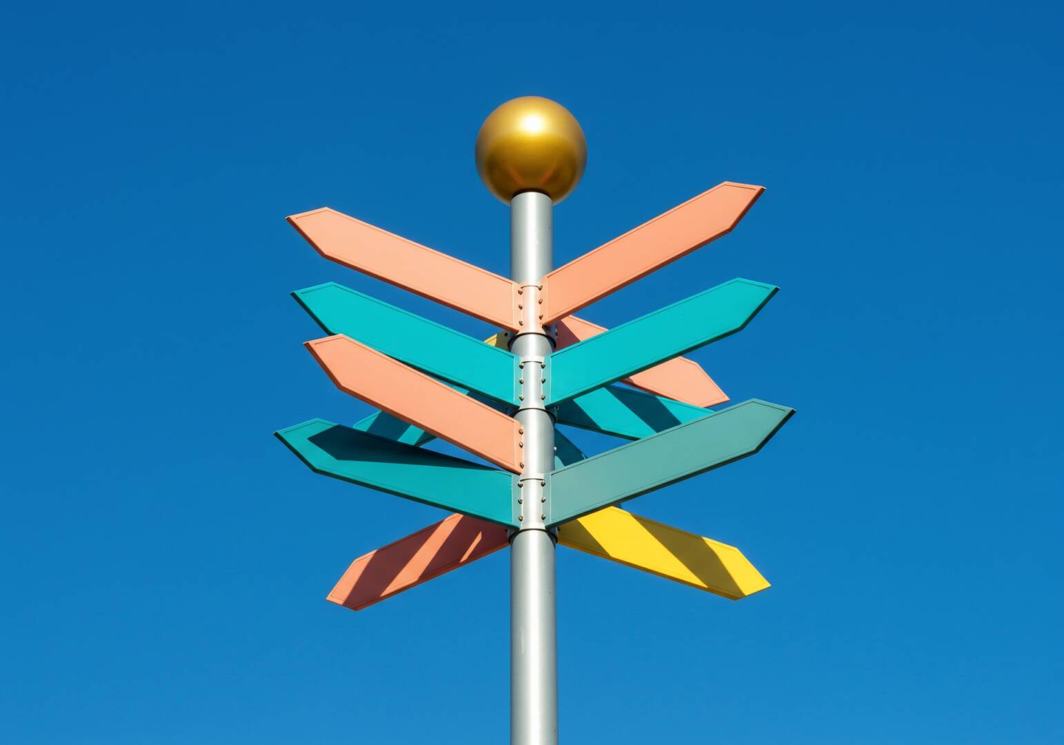 Signpost against clear blue sky background indicating choice of directions